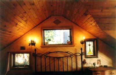 lighted room with vaulted ceiling and wood walls