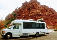 Camperized bus in front of rocks